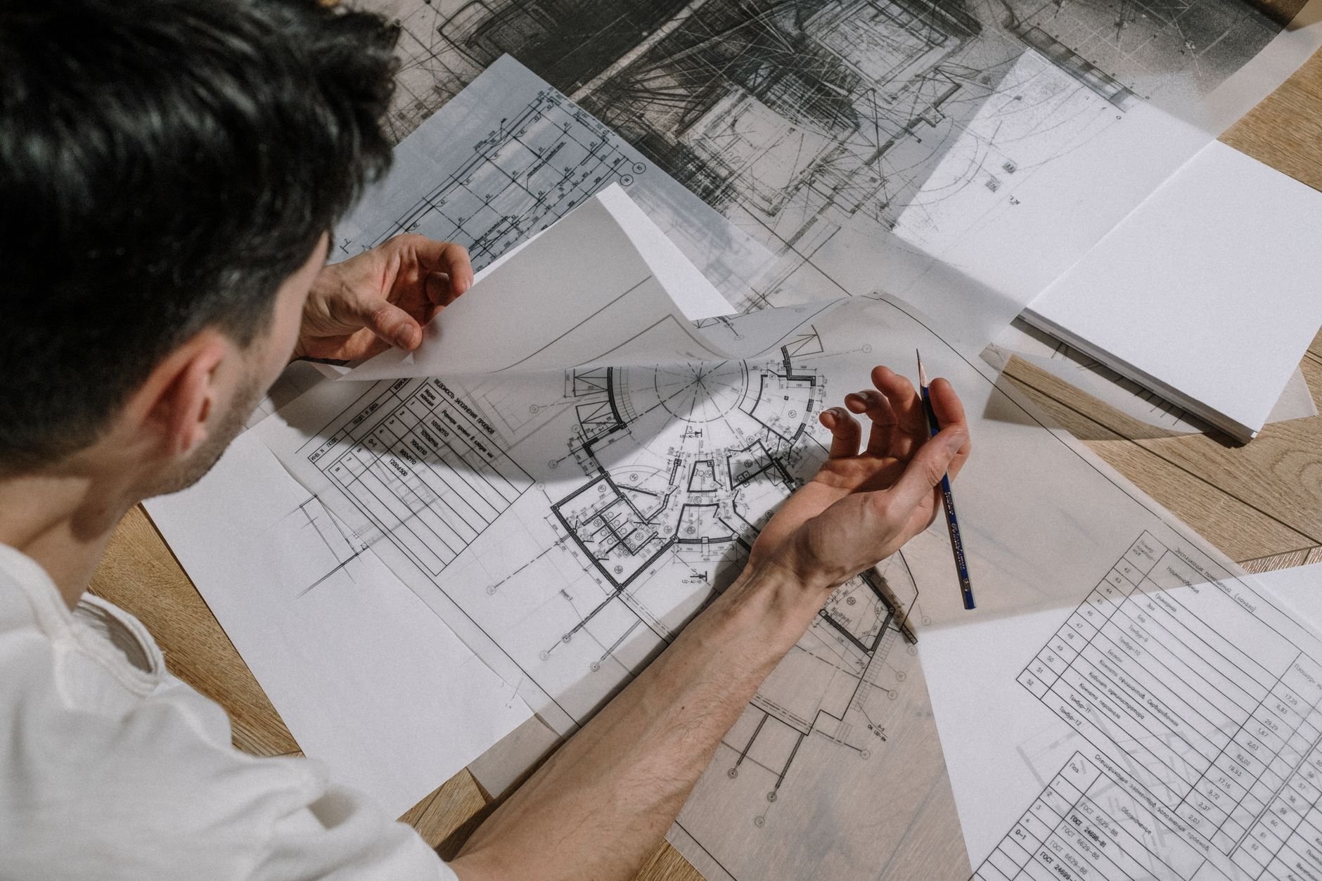 Architect studying detailed floor plans at a desk